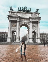 Woman walking in front of historical building