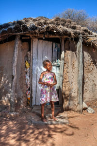 Full length of woman standing against wall