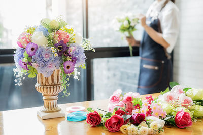 Flower vase on table against wall