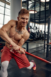 Portrait of young man exercising in gym