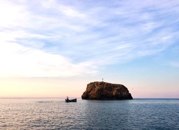 Scenic view of rock formation in sea against sky