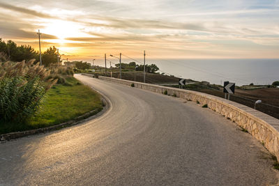 Road amidst landscape against sky during sunset