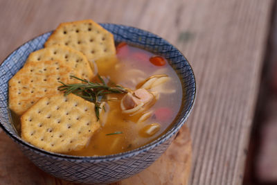 High angle view of soup with crackers on wooden table