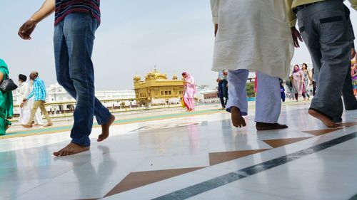 Low section of people standing on tiled floor