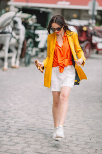Portrait of young woman standing on road