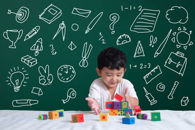 Cute boy with toys on table