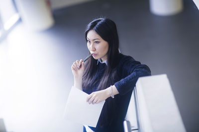 Young asia woman with paper in an office standing with pen