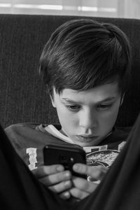 Portrait of boy using mobile phone at home