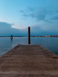 Wooden pier over sea against sky