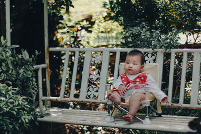 Full length of cute girl sitting outdoors