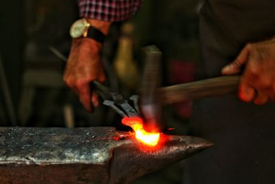 Midsection of blacksmith working at workshop