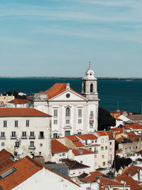 High angle view of townscape by sea against sky