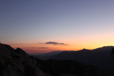 Scenic view of silhouette mountains against clear sky during sunset