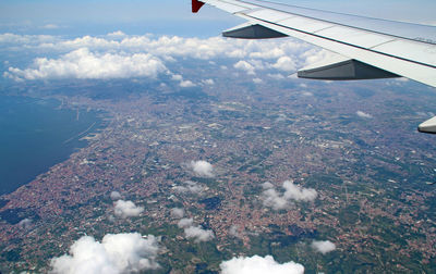 Aerial view of aircraft wing over landscape against sky