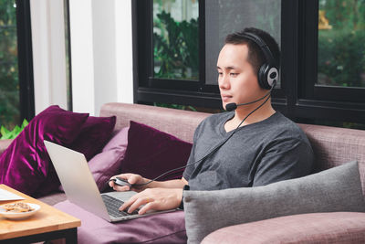 Man wearing headphone talking on video conference at home