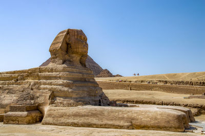 The sphinx statue in desert against clear blue sky