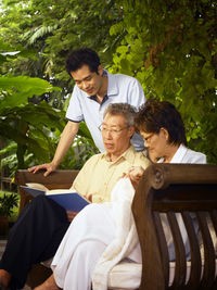 Family reading book at back yard