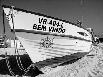 Close-up of boat moored at harbor against sky