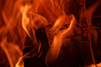 Close-up of firewood burning in red flames of fire in the fireplace