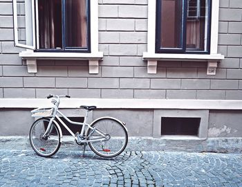Bicycle parked on street against building