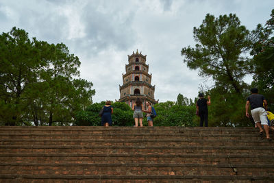 Tourists at temple against sky