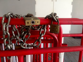 Close-up of padlocks on chain against wall