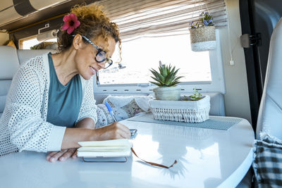 Young woman using mobile phone while sitting at home