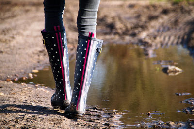 Low section of woman walking on dirt road