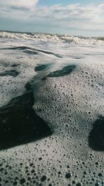 Surface level of sandy beach against sky