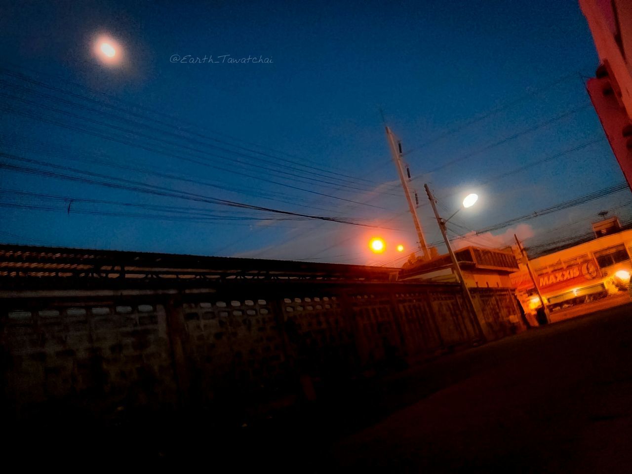 illuminated, night, street light, electricity, power line, sky, built structure, clear sky, connection, lighting equipment, cable, low angle view, blue, architecture, dusk, building exterior, silhouette, power supply, electricity pylon, copy space