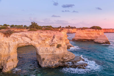 Scenic view of rock formation in sea against sky