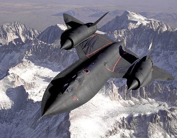 HIGH ANGLE VIEW OF AIRPLANE FLYING OVER SNOWCAPPED MOUNTAINS