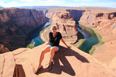 Portrait of woman sitting on mountain at horseshoe bend