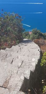 High angle view of rocks by sea against sky