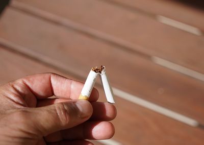 Close-up of hand breaking cigarette