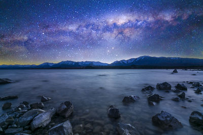 Scenic view of lake against sky at night