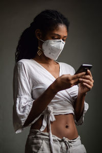 Woman with face mask using a smartphone
