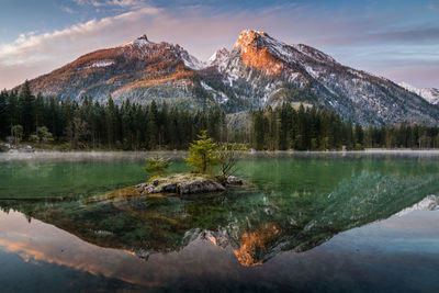 Scenic view of lake by mountains against sky