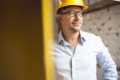 Man working against yellow wall