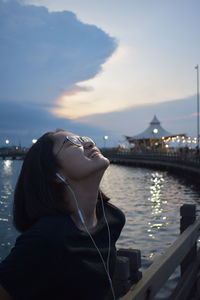 Portrait of woman looking at lake against sky