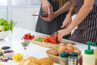 Midsection of people on table at home