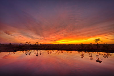 Scenic view of lake against orange sky