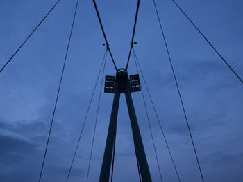 Low angle view of overhead cable cars against sky