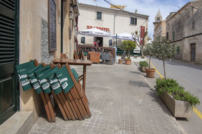 Empty chairs and tables in cafe amidst buildings in city