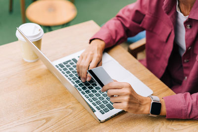 Close-up of female hands, credit card and laptop keyboard.