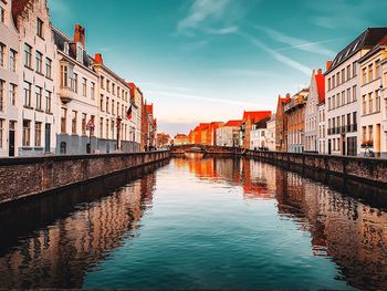 Canal amidst buildings against sky