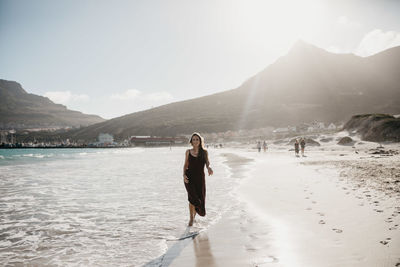 Woman standing on mountain against sky