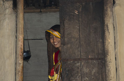 Portrait of smiling woman wearing sari standing at door