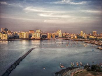 River in city against cloudy sky