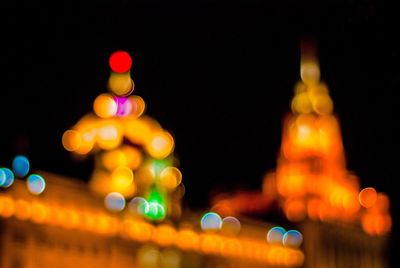 Defocused image of illuminated city against sky at night